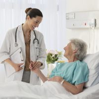 Doctor and senior patient talking in hospital room